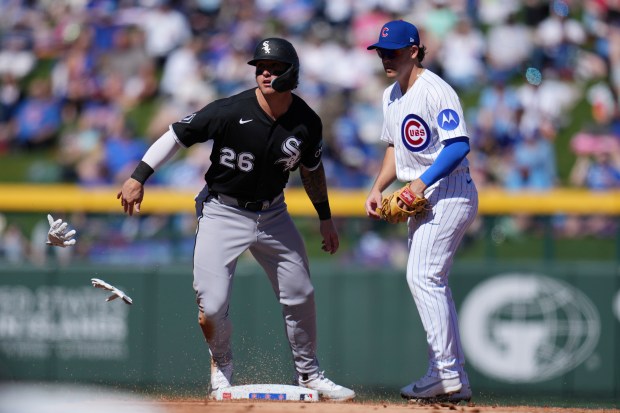 Chicago White Sox's Korey Lee loses his batting gloves after stealing second base as Chicago Cubs' Scott Kingery looks on during the second inning of a spring training game on Friday, Feb. 20, 2026, in Mesa, Ariz. (AP Photo/Ross D. Franklin)