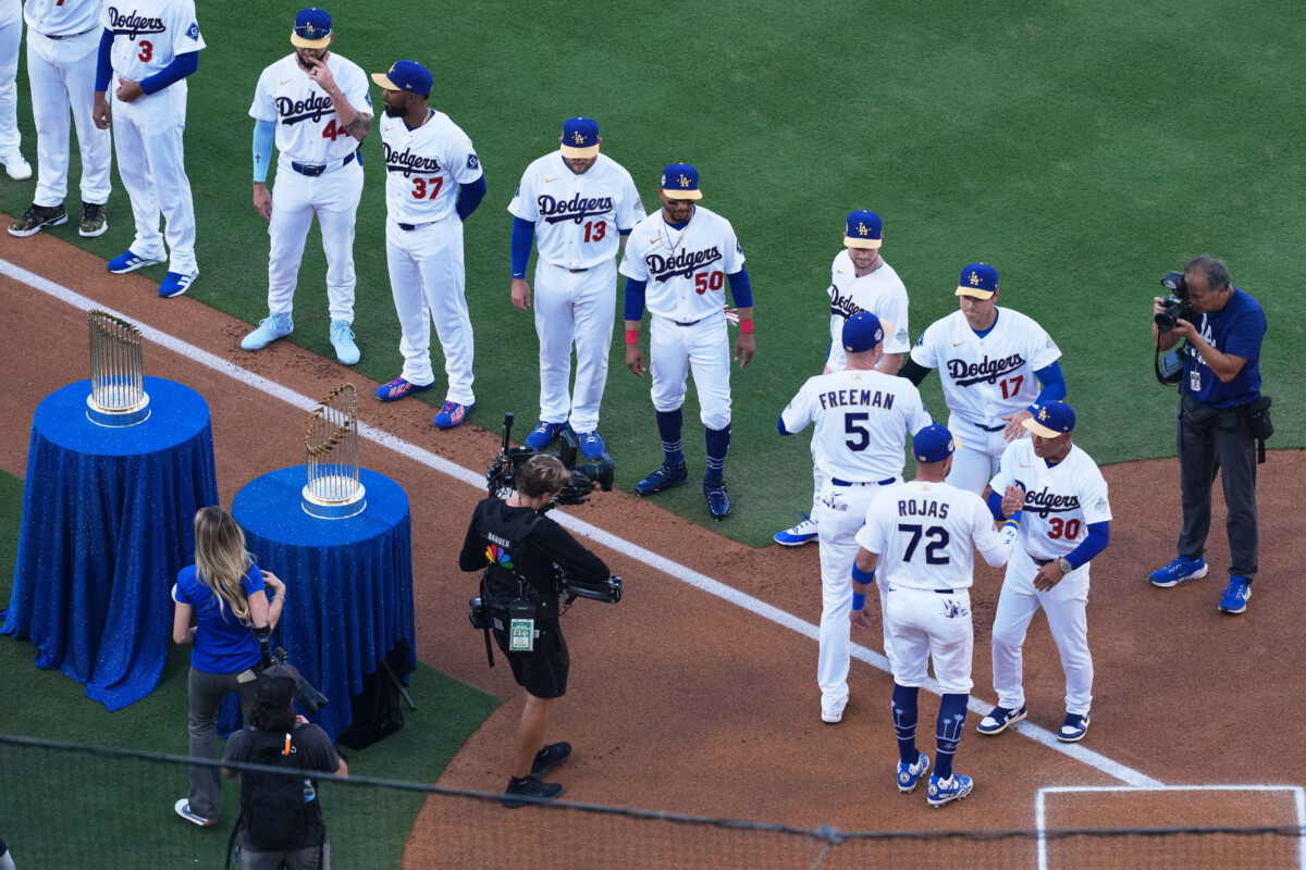 Mar 26, 2026; Los Angeles, California, USA; Los Angeles Dodgers infielders Freddie Freeman (5) and Miguel Rojas (72) greet manager Dave Roberts (30) and designated hitter Shohei Ohtani before the game against the Arizona Diamondbacks at Dodger Stadium. Mandatory Credit: Kirby Lee-Imagn Images