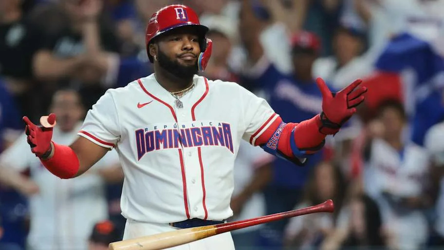 Guerrero Jr. drops his bat after hitting a two run homerun in a white jerse