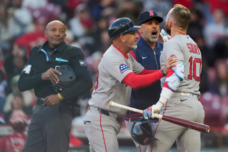 Boston shortstop Trevor Story exchanges words with umpire CB Bucknor, as first base coach José David Flores, and manager Alex Cora usher him to the dugout during the eighth inning of the Red Sox’s 6-5, 11-inning loss to the host Reds on March 28, 2026 at Great American Ball Park. IMAGN IMAGES via Reuters Connect