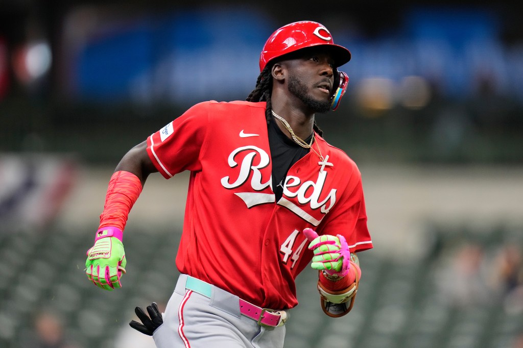 Baseball player Elly de la Cruz of the Cincinnati Reds in red uniform running the bases.