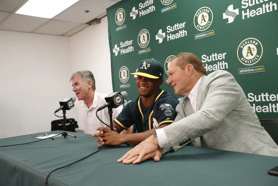 Executive Vice President of Baseball Operations Billy Beane of the Oakland Athletics, first round draft pick Kyler Murray and Agent Scott Boras talk during a press conference after Murray signed his contact at the Oakland Alameda Coliseum on June 15, 2018 in Oakland, California. 