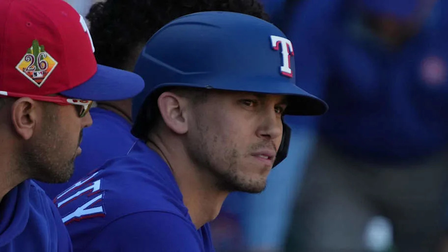 Texas Rangers center fielder Sam Haggerty sits with his bat during a game. 