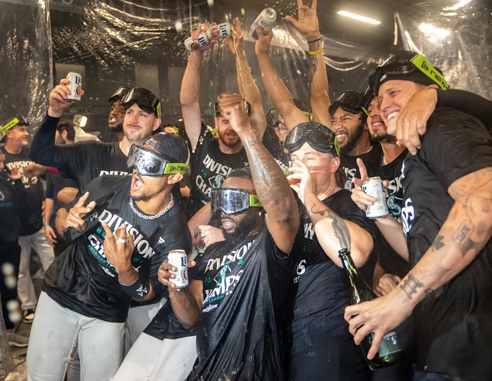 Seattle Mariners including centerfielder Julio Rodriguez (44), left, and Randy Arozarena (56), center, celebrate after winning the American League West Division in a game against the Colorado Rockies at T-Mobile Park. Stephen Brashear-Imagn Images