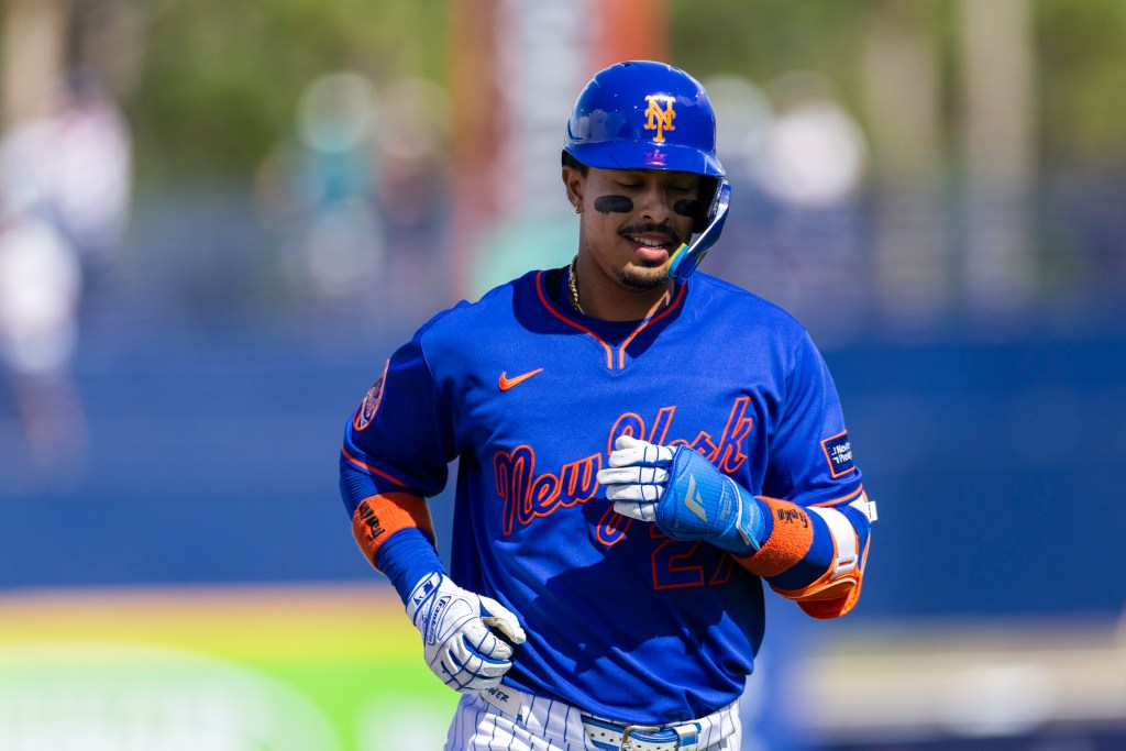 New York Mets infielder Mark Vientos (27) in a blue uniform and helmet with orange "NY" logo and black eye black.