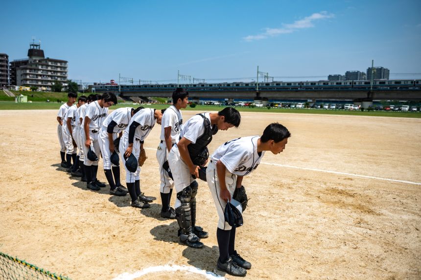 Players from the Ota Dreams bow before a high school baseball game in Tokyo in 2021.