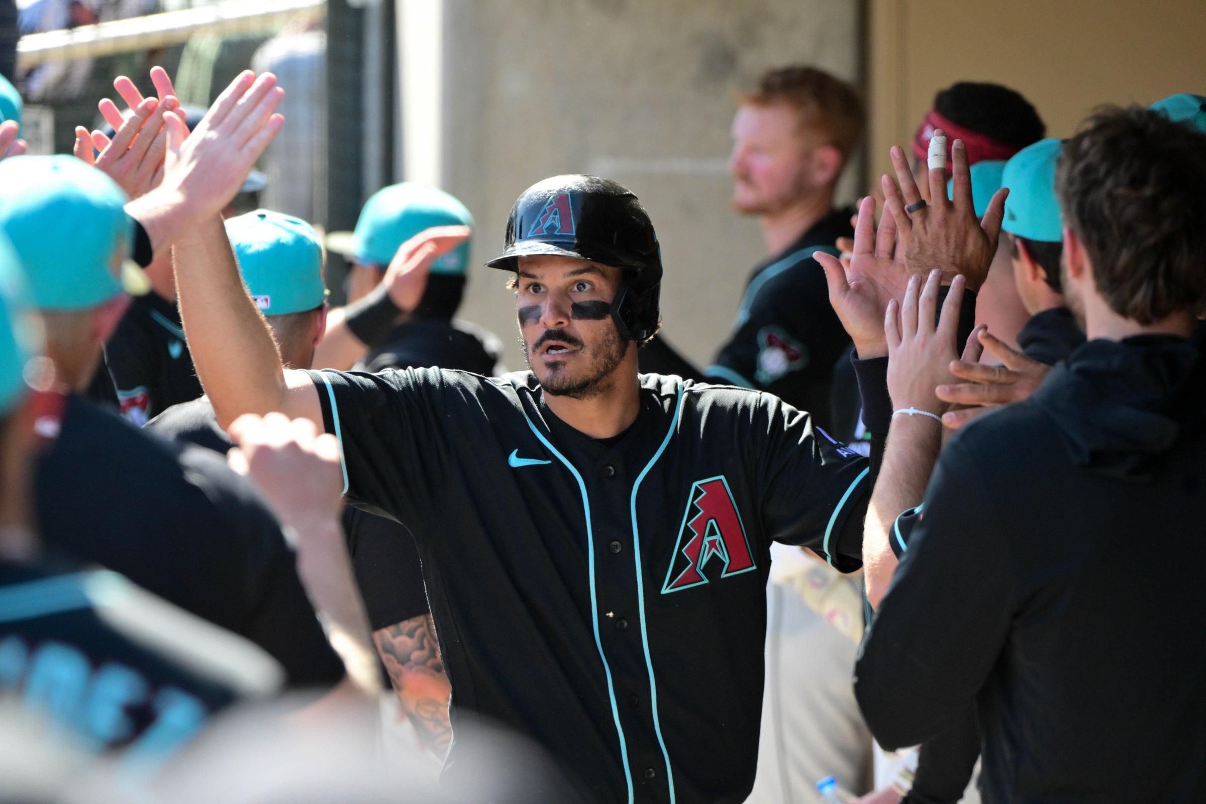 Feb 25, 2026; Salt River Pima-Maricopa, Arizona, USA; Arizona Diamondbacks third baseman Nolan Arenado (28) celebrates with teammates after scoring a run in the first inning against the Los Angeles Dodgers at Salt River Fields at Talking Stick. Mandatory Credit: Matt Kartozian-Imagn Images