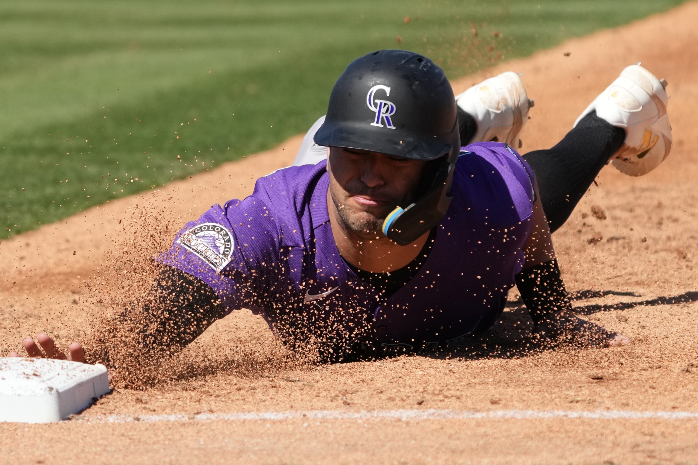 Mar 6, 2026; Mesa, Arizona, USA; Colorado Rockies right fielder Tyler Freeman (2) dives back into first base against the Athletics in the second inning at Hohokam Stadium. Mandatory Credit: Rick Scuteri-Imagn Images
