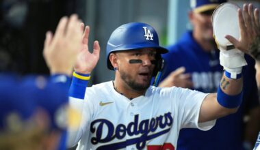 Los Angeles Dodgers infielder Miguel Rojas (72) shakes hands with teammates in the dugout after scoring a run on an infield single hit by catcher Will Smith (not pictured) against the Arizona Diamondbacks during the fifth inning at Dodger Stadium.