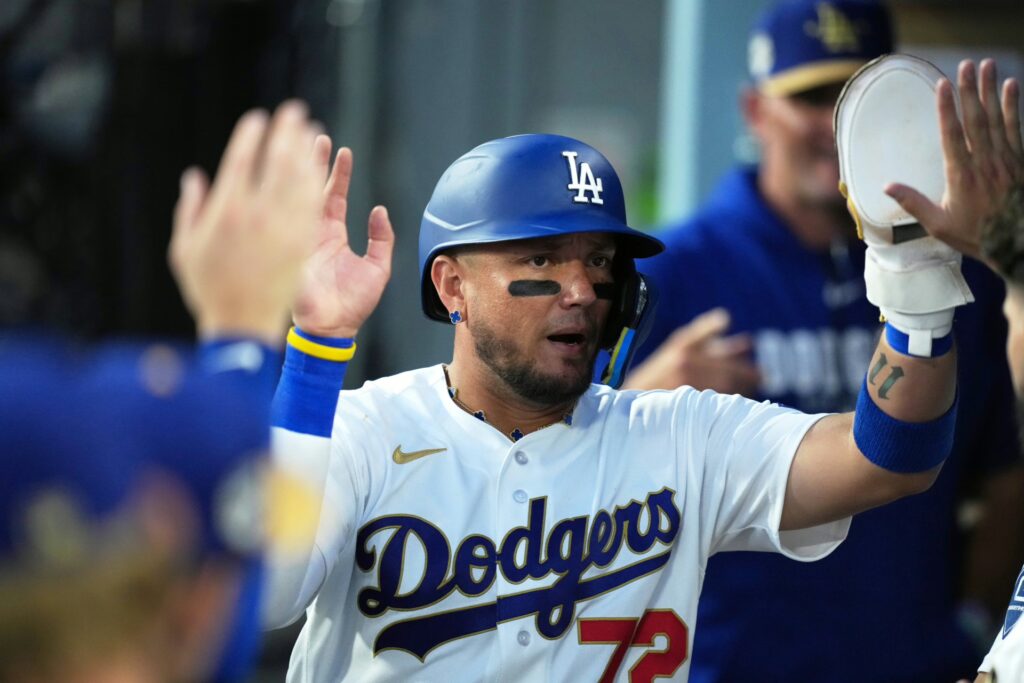 Los Angeles Dodgers infielder Miguel Rojas (72) shakes hands with teammates in the dugout after scoring a run on an infield single hit by catcher Will Smith (not pictured) against the Arizona Diamondbacks during the fifth inning at Dodger Stadium.