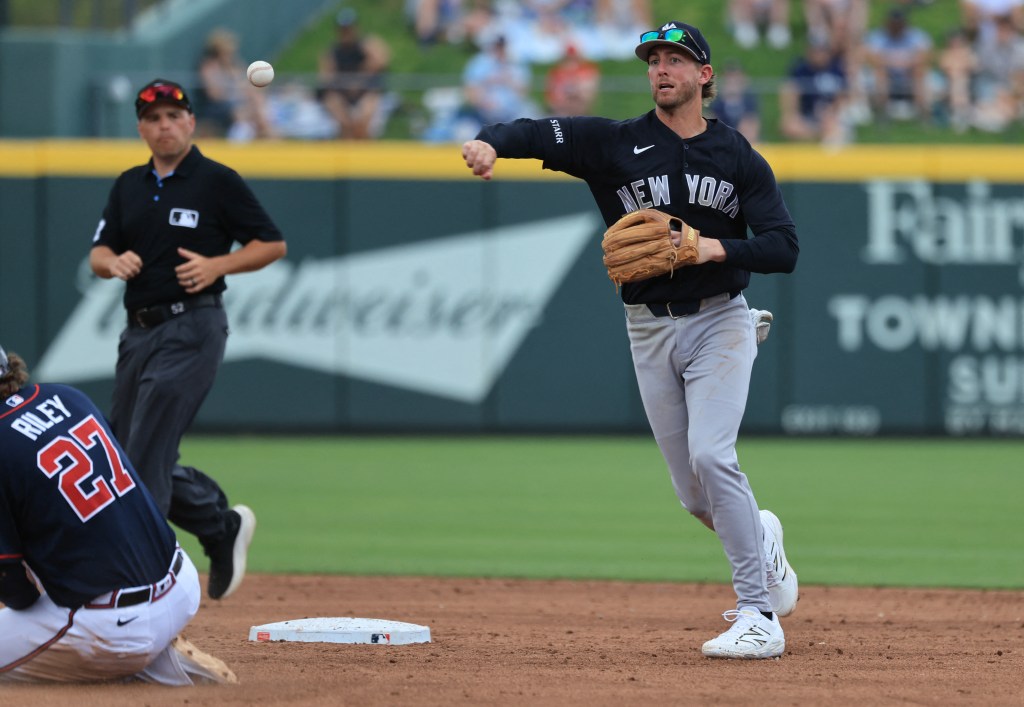 New York Yankees infielder Ryan McMahon throws the ball after forcing out Atlanta Braves third baseman Austin Riley for a double play.