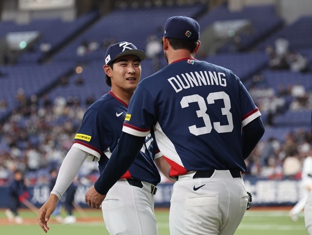 At the World Baseball Classic warm-up match between the Korean national team and the Orix Buffaloes in Japanese pro baseball at Kyocera Dome in Osaka, Japan on Sunday. Korean pitcher Dane Dunning (right) enters the dugout to cheer up Shay Wittcomb and each other after finishing the third inning without allowing a run. Photo = Yonhap News