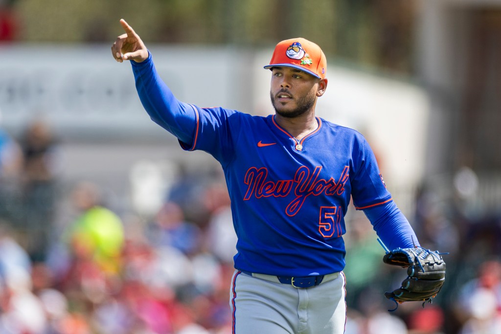 New York Mets pitcher Freddy Peralta points during a Spring Training game.