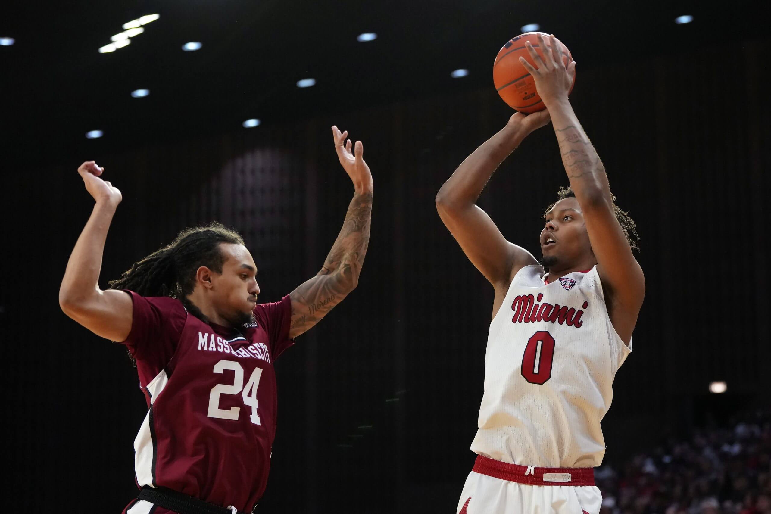 Eian Elmer #0 of the Miami (OH) RedHawks shoots against Marcus Banks Jr. #24 of the UMass Minutemen in the second half at Millett Hall on January 27, 2026 in Oxford, Ohio.