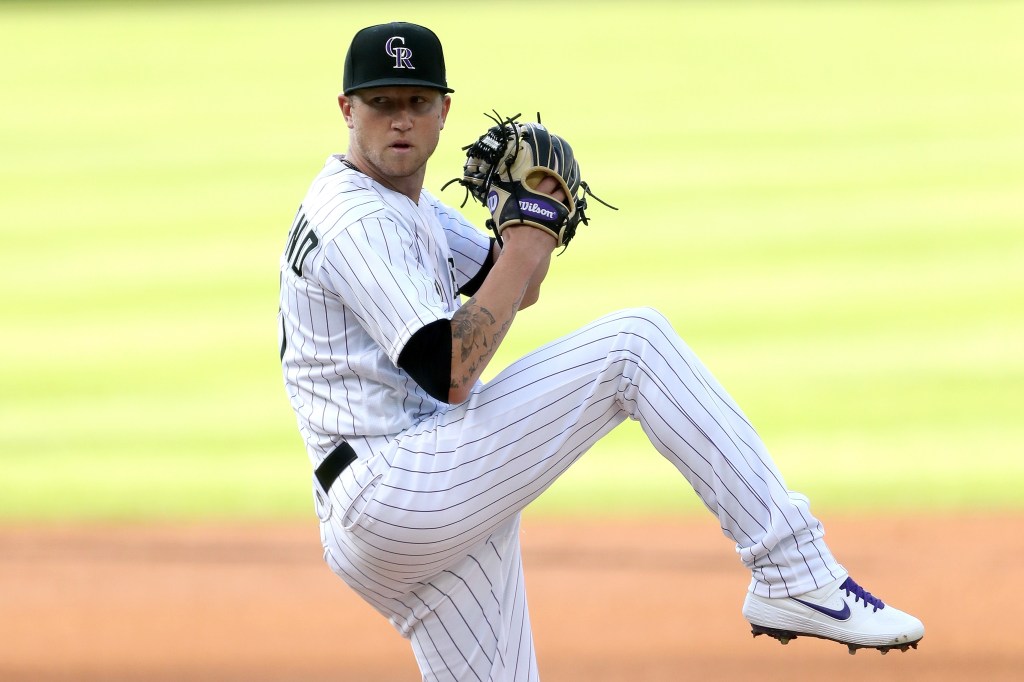 Starting pitcher Kyle Freeland #21 of the Colorado Rockies in a white uniform with black pinstripes throws during the first inning.