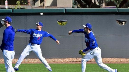 Los Angeles Dodgers pitcher Roki Sasaki (11) and pitcher Blake Snell (7) warm up during a Spring Training workout at Camelback Ranch. 