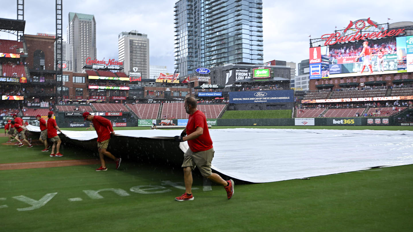 Jul 13, 2025; St. Louis, Missouri, USA;  St. Louis Cardinals grounds crew pulls the tarp on the field during a rain delay in the third inning of a game between the St. Louis Cardinals and the Atlanta Braves at Busch Stadium. Mandatory Credit: Jeff Curry-Imagn Images