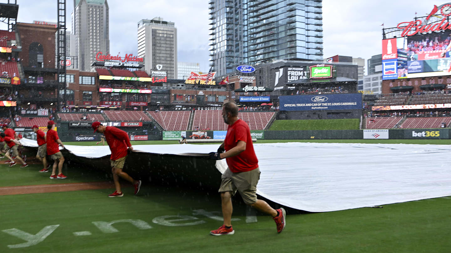 Jul 13, 2025; St. Louis, Missouri, USA;  St. Louis Cardinals grounds crew pulls the tarp on the field during a rain delay in the third inning of a game between the St. Louis Cardinals and the Atlanta Braves at Busch Stadium. Mandatory Credit: Jeff Curry-Imagn Images