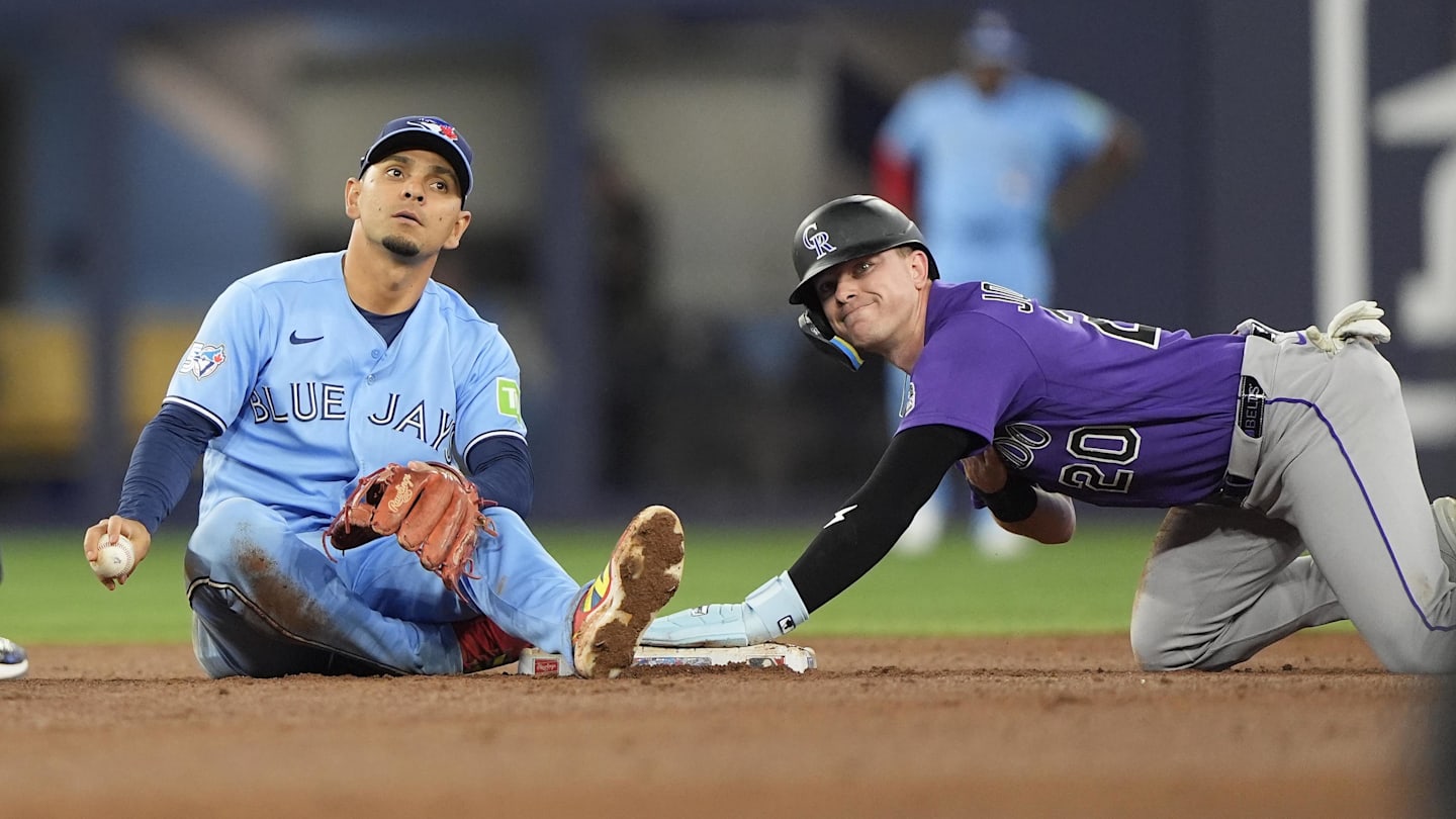 Apr 1, 2026; Toronto, Ontario, CAN; Colorado Rockies right fielder Troy Johnston (20) reacts after stealing second base against Toronto Blue Jays shortstop Andres Gimenez (0) during the eighth inning at Rogers Centre. Mandatory Credit: John E. Sokolowski-Imagn Images