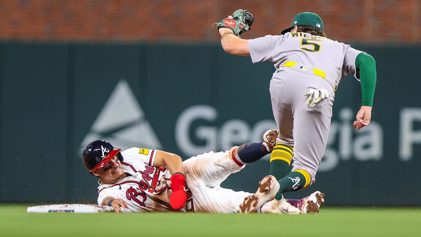 Mar 30, 2026; Cumberland, Georgia, USA; Athletics shortstop Jacob Wilson (5) makes a tag for an out against Atlanta Braves catcher Drake Baldwin (30) during the ninth inning at Truist Park. Mandatory Credit: Jordan Godfree-Imagn Images