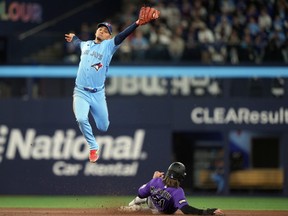 Colorado Rockies’ Jake McCarthy steals second base as Toronto Blue Jays second baseman Andrés Giménez tries to make the tag during Wednesday’s game.