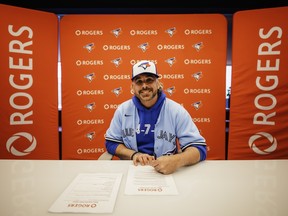Rogers Game Day Owner Paul Bychko signs his contract.
