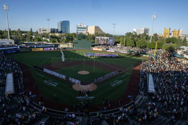 Athletics and Houston Astros players stand on the first and third base lines during the playing of the national anthem on Opening Day, on Friday at Sutter Health Park in West Sacramento.