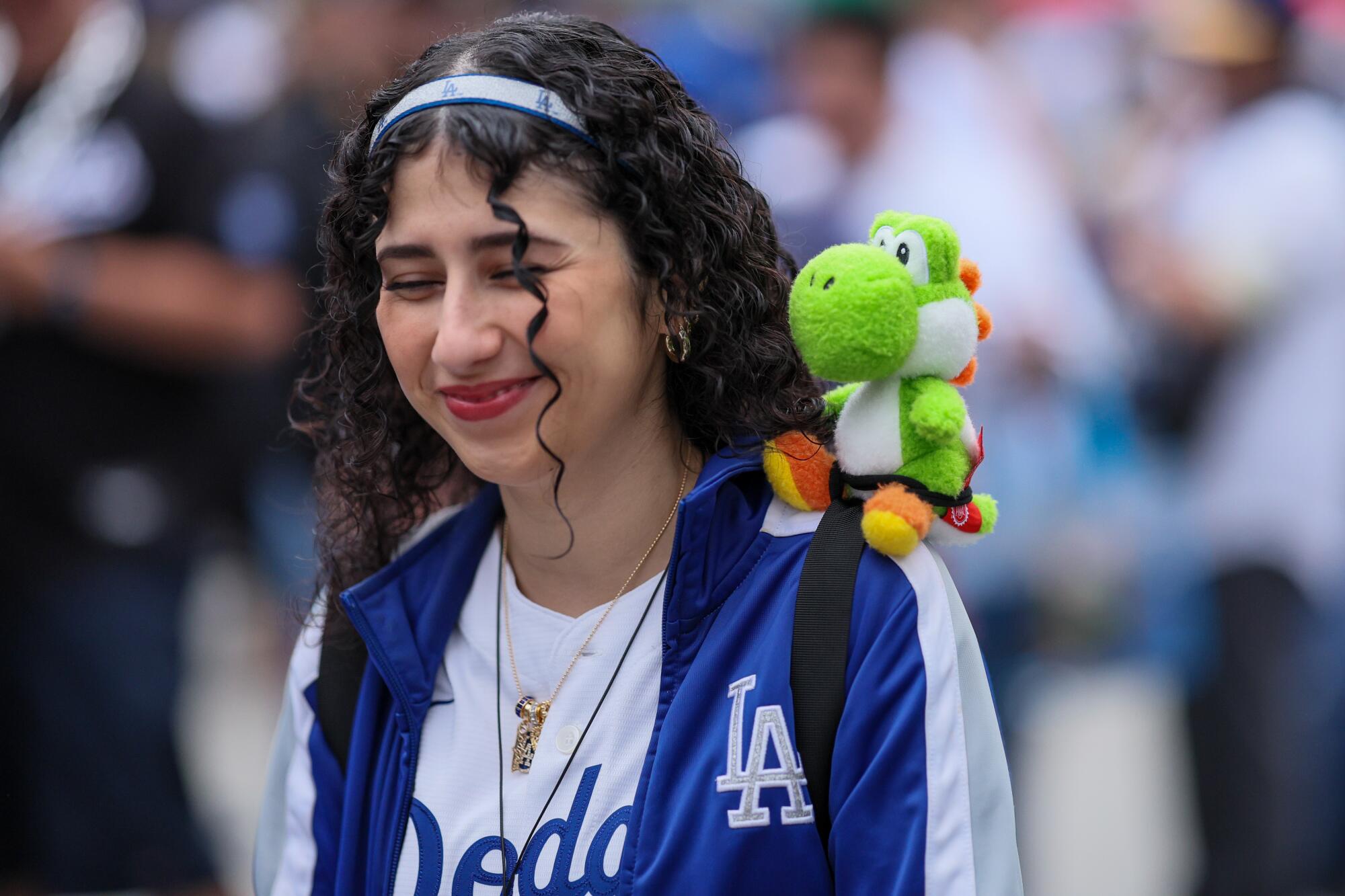 A Dodgers fan wears a Yoshi plush doll before Yoshi bobblehead night at the Dodgers-Guardians game.