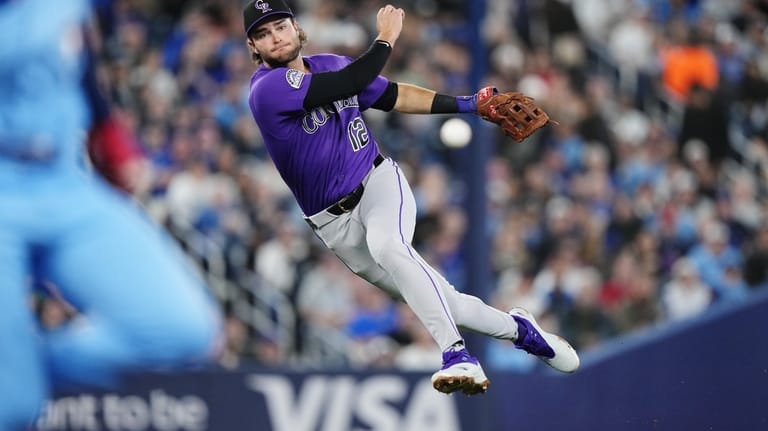 Colorado Rockies third baseman Kyle Karros (12) throws to first...