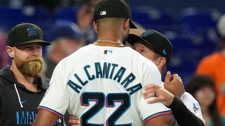 Miami Marlins manager Clayton McCullough, right, embraces starting pitcher Sandy...