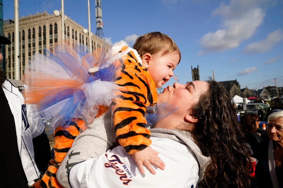 Natalie Clor, 31, of Harper Woods, lifts up her 15-month-old Juliette as they tailgate in Detroit before the Detroit Tigers take on the St. Louis Cardinals for Opening Day at Comerica Park in Detroit on Friday, April 3, 2026