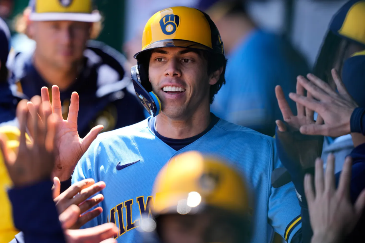 Milwaukee Brewers' Christian Yelich celebrates in the dugout after scoring on a double by Garrett Mitchell during the first inning in the first baseball game of a doubleheader against the Kansas City Royals, Saturday, April 4, 2026, in Kansas City, Mo.