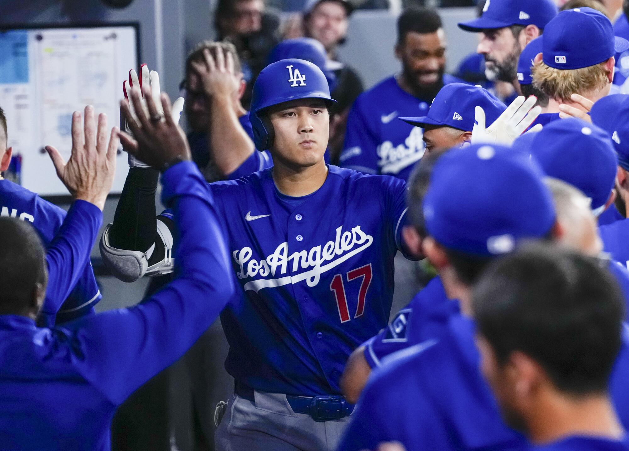 Dodgers star Shohei Ohtani celebrates in the dugout after hitting a home run in the sixth inning.