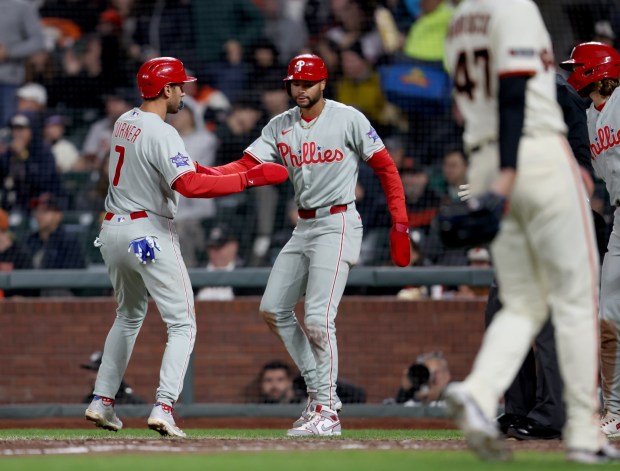 Philadelphia Phillies' Trea Turner #7 and Justin Crawford #2 celebrate after scoring on a single by teammate Bryce Harper #3 as San Francisco Giants relief pitcher Ryan Borucki #47 looks on in the seventh inning of their MLB game at Oracle Park in San Francisco, Calif., on Monday, April 6, 2026. (Jane Tyska/Bay Area News Group)
