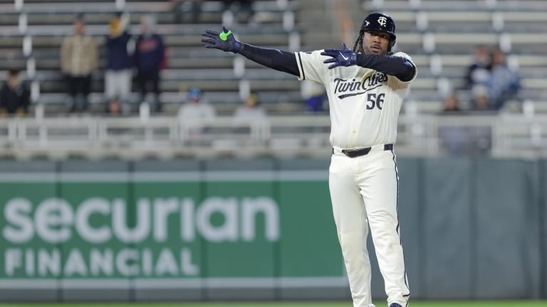 Minnesota Twins designated hitter Josh Bell celebrates hitting an RBI-double...