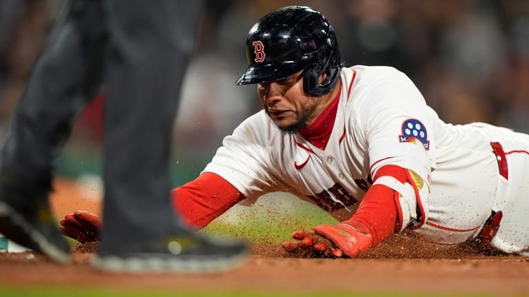 Boston Red Sox Willson Contreras dives back to first base...