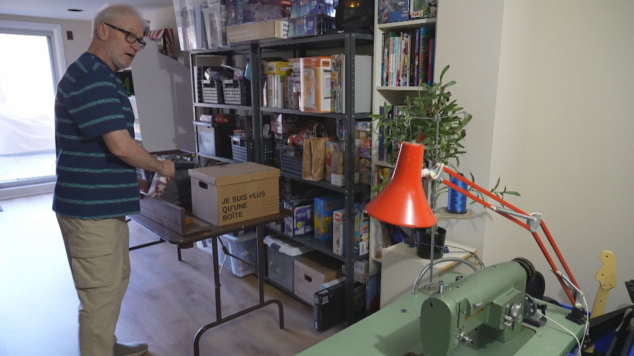 Man with glasses in basement looking at sewing machine
