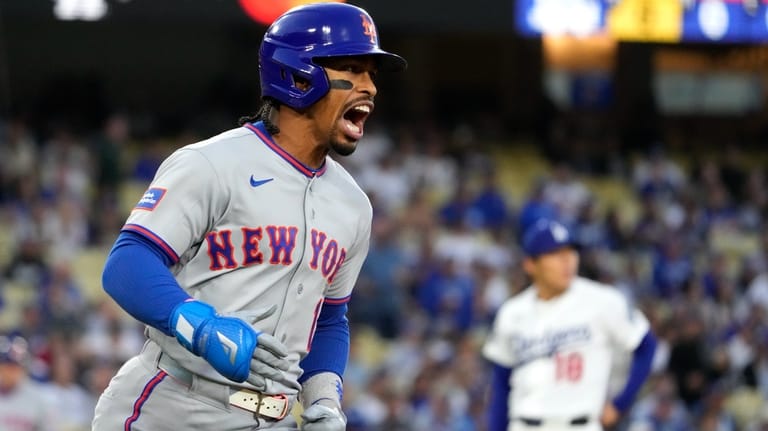 New York Mets' Francisco Lindor, left, celebrates as he heads...