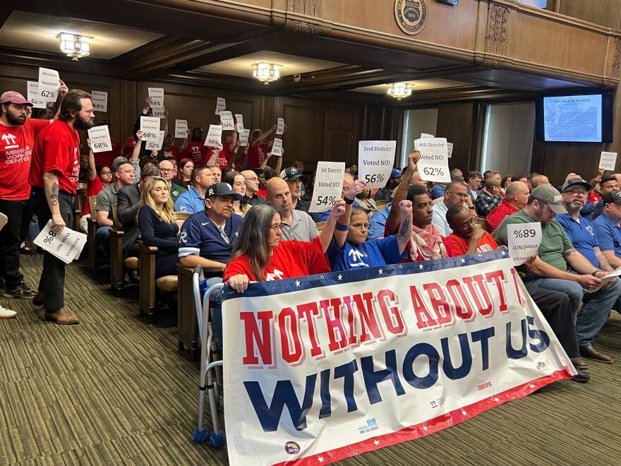 Members of Stand Up KC and the Missouri Workers Center pack Kansas City Council chambers on Thursday to oppose the passage of a financing deal for a new Royals stadium. Sitting behind and around them are members of the building trades unions, who support the deal.