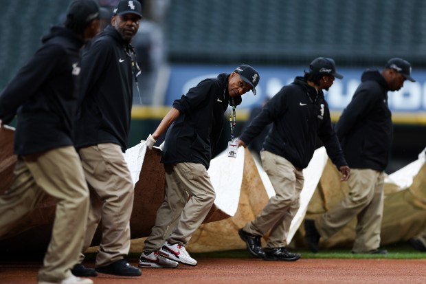 Members of the grounds crew cover the field with a tarp as the game between the White Sox and Angels was delayed because of rain Monday, April 27, 2026, at Rate Field. (Armando L. Sanchez/Chicago Tribune)