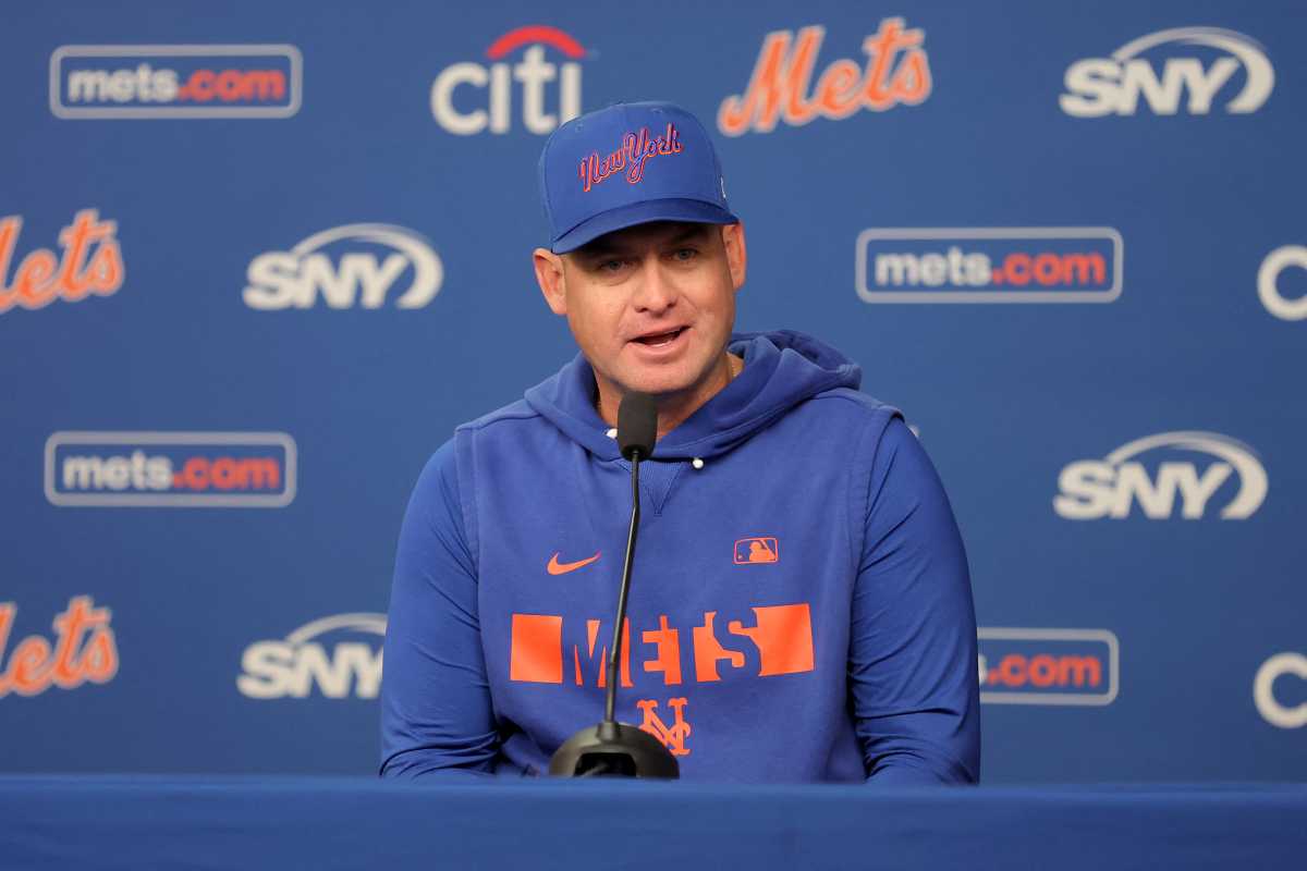 Carlos Mendoza Mets: Man in blue hat and sweatshirt sits in front of blue backdrop