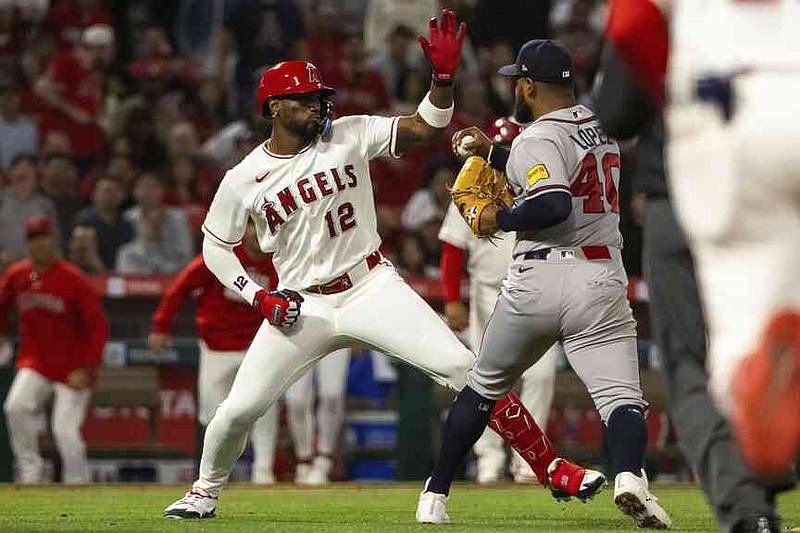 Los Angeles Angels' Jorge Soler (12) and Atlanta Braves' Reynaldo López (40) fight during the fifth inning of a baseball game, Tuesday, April 7, 2026, in Anaheim, Calif. (AP Photo/Ethan Swope)