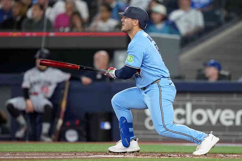 Toronto Blue Jays' Daulton Varsho (5) watches the ball as he hits a two-run home run against the Minnesota Twins during the first inning of a baseball game in Toronto, Saturday, April 11, 2026. (Nathan Denette/The Canadian Press via AP)
