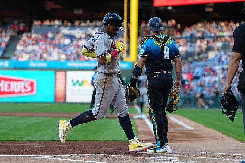 Atlanta Braves' Ronald Acuña Jr. scores past Philadelphia Phillies catcher J.T. Realmuto off of a hit by teammate Ozzie Albies during the first inning of a baseball game, Friday, April 17, 2026, in Philadelphia. (AP Photo/Matt Rourke)