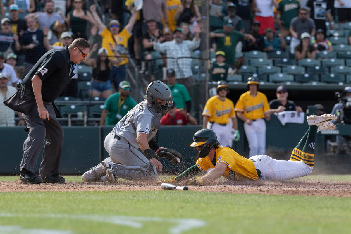Chicago White Sox catcher Reese McGuire, center, attempts to get Athletics' Jacob Wilson o ...