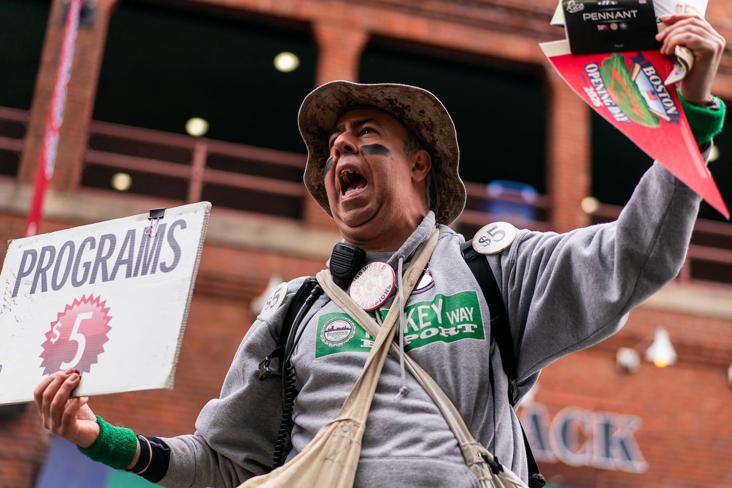 Sly Egidio of East Boston hollers “programs for sale” outside of Fenway Park. Sly’s first opening day was 1992 as an employee of the magazine, and he now owns the company. Sly said, “Anytime they get a ring, that’s the best opening day.”