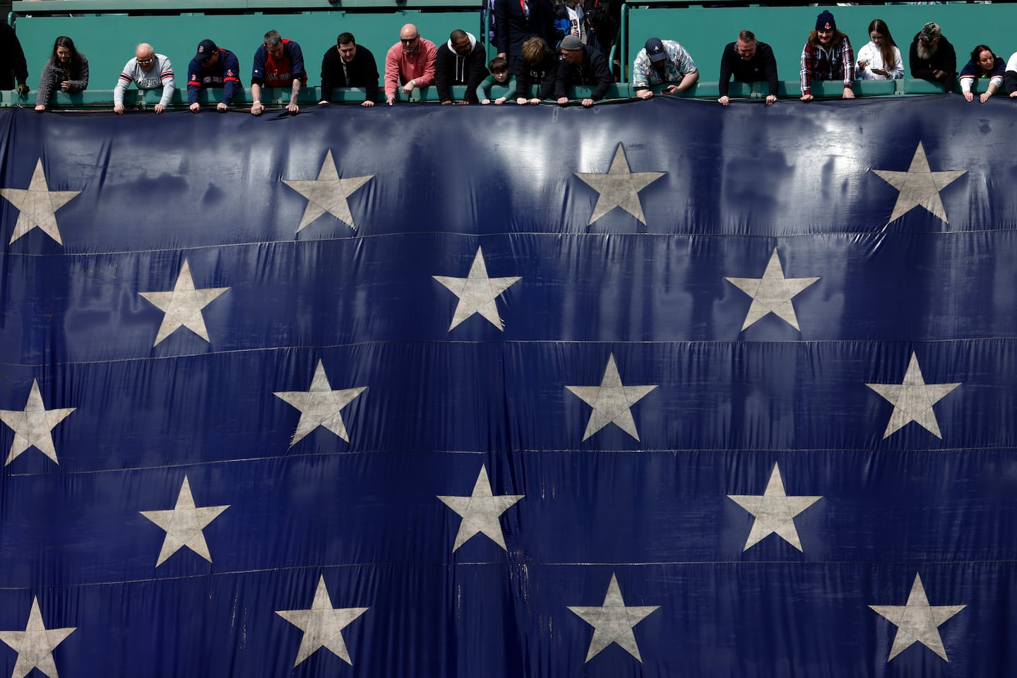Fans hold a giant American flag during the Opening Day ceremony.