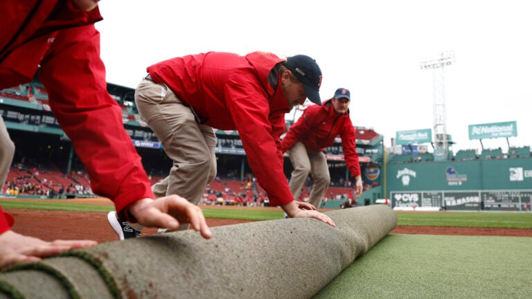 The Fenway Park field crew prepare the field before the season home opener against the San Diego Padres on April 3, 2026 in Boston.