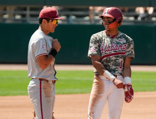 April 12, 2026; Tuscaloosa, AL, USA; Alabama base runner Justin Lebron (1) talks to Arkansas second baseman Nolan Souza during a replay review at Sewell-Thomas Stadium in game 3 of the weekend series between Alabama and Arkansas.