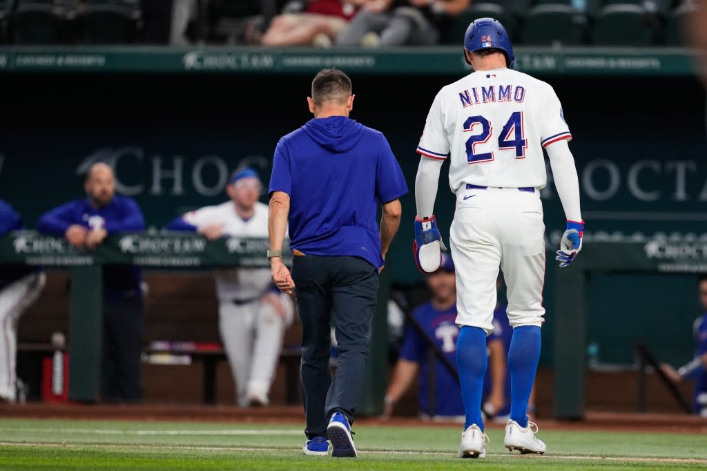 Texas Rangers’ Brandon Nimmo (24) walks off the field with head athletic trainer Matt Lucero in the fifth inning on April 29, 2026, in Arlington, Texas. AP